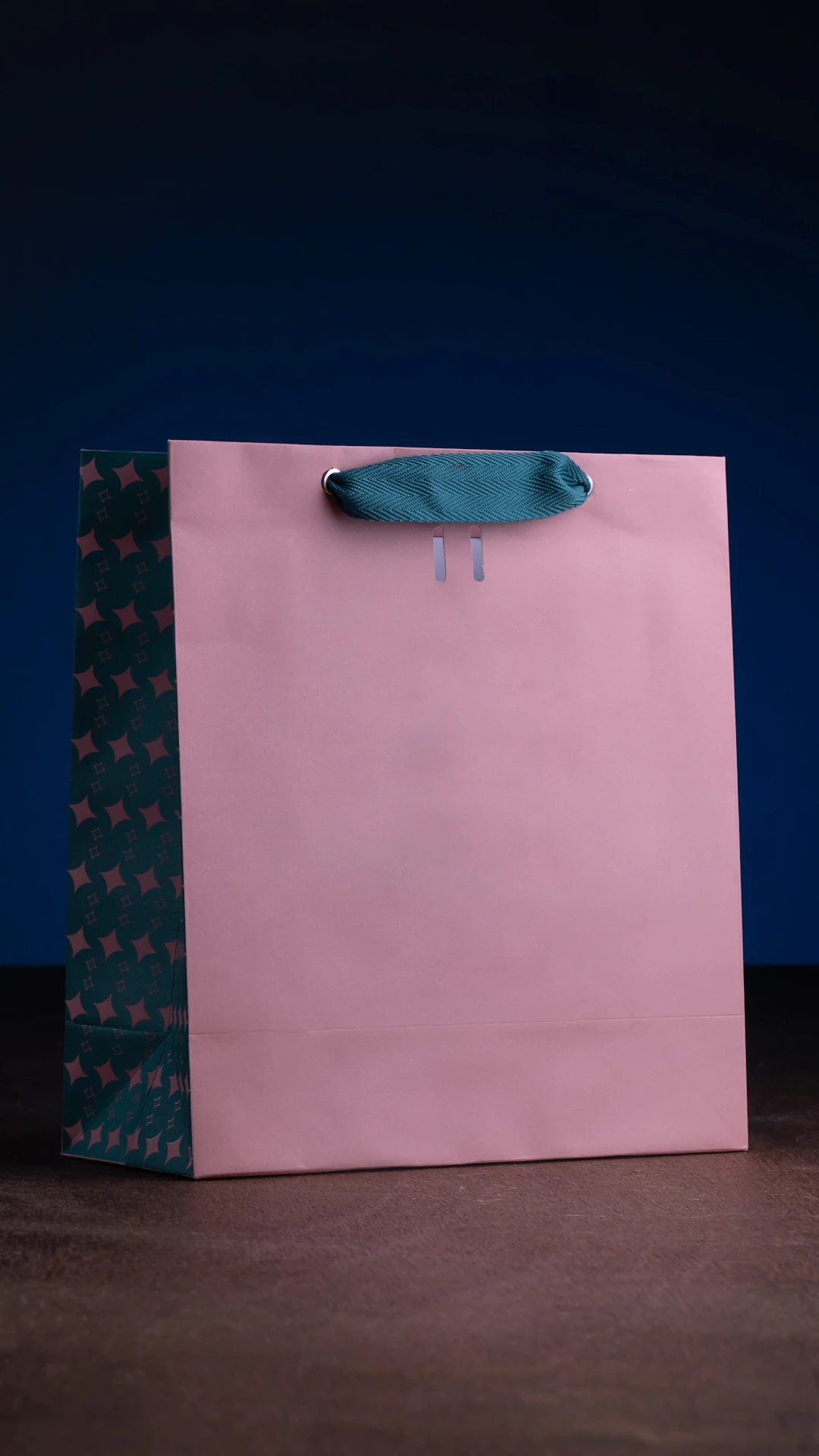 a pink shopping bag with a blue handle